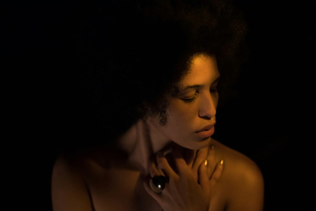 Woman in a dark room, contemplating. self-forgiveness.