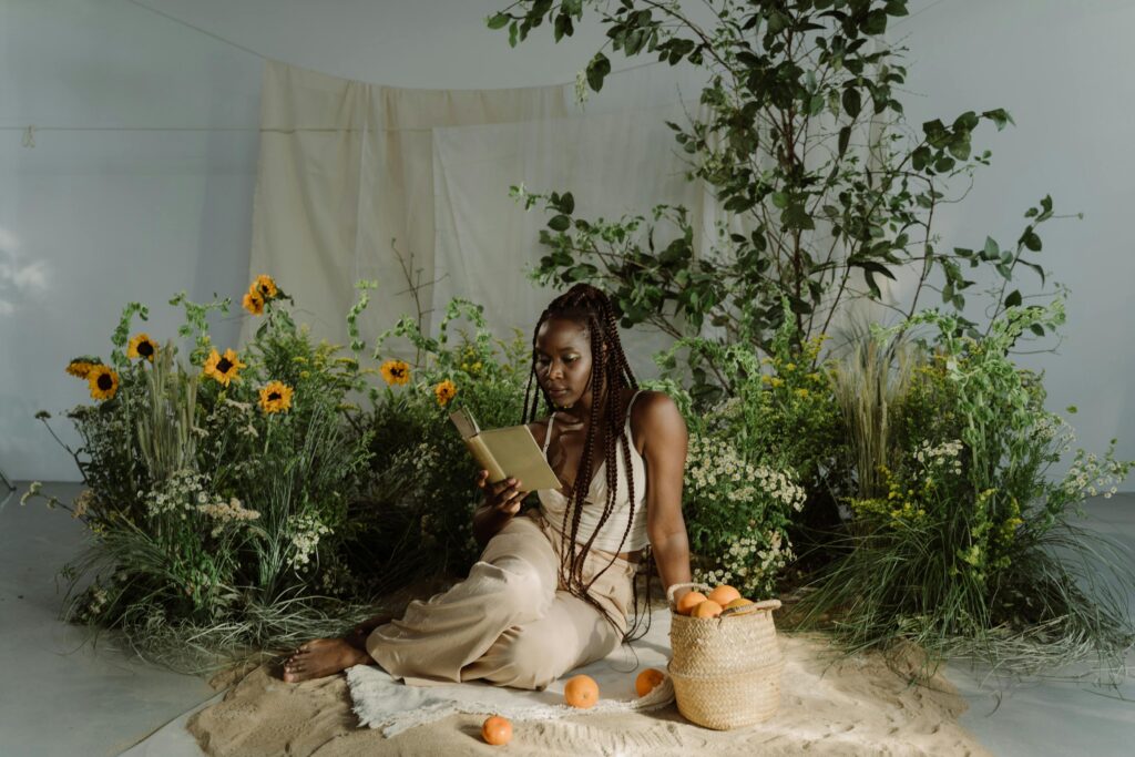 woman reading surrounded by sunflowers and plants